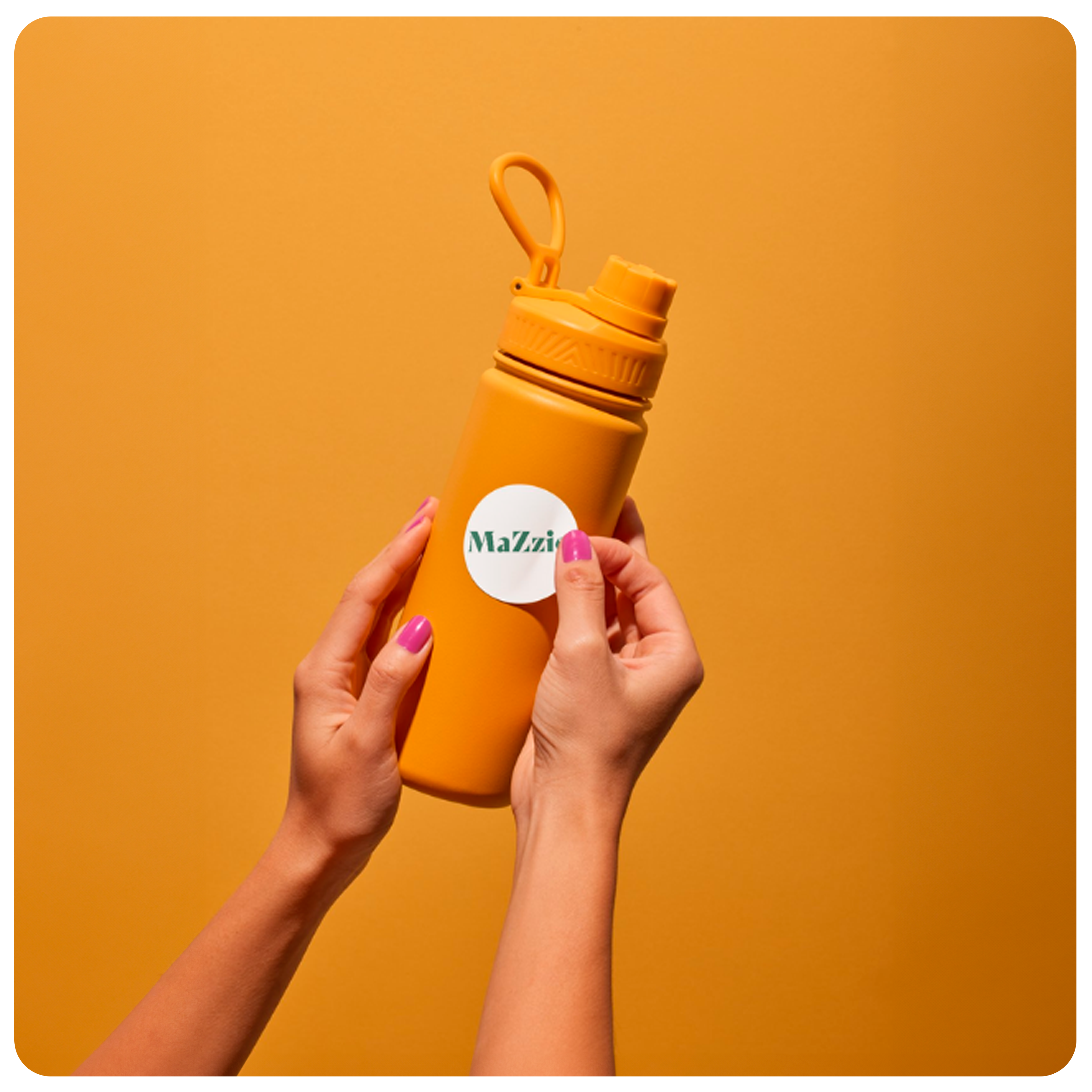 Une gourde de couleur orange avec les mains d'une femme qui pose un stickers de la marque MaZzio.fr sur le côté.