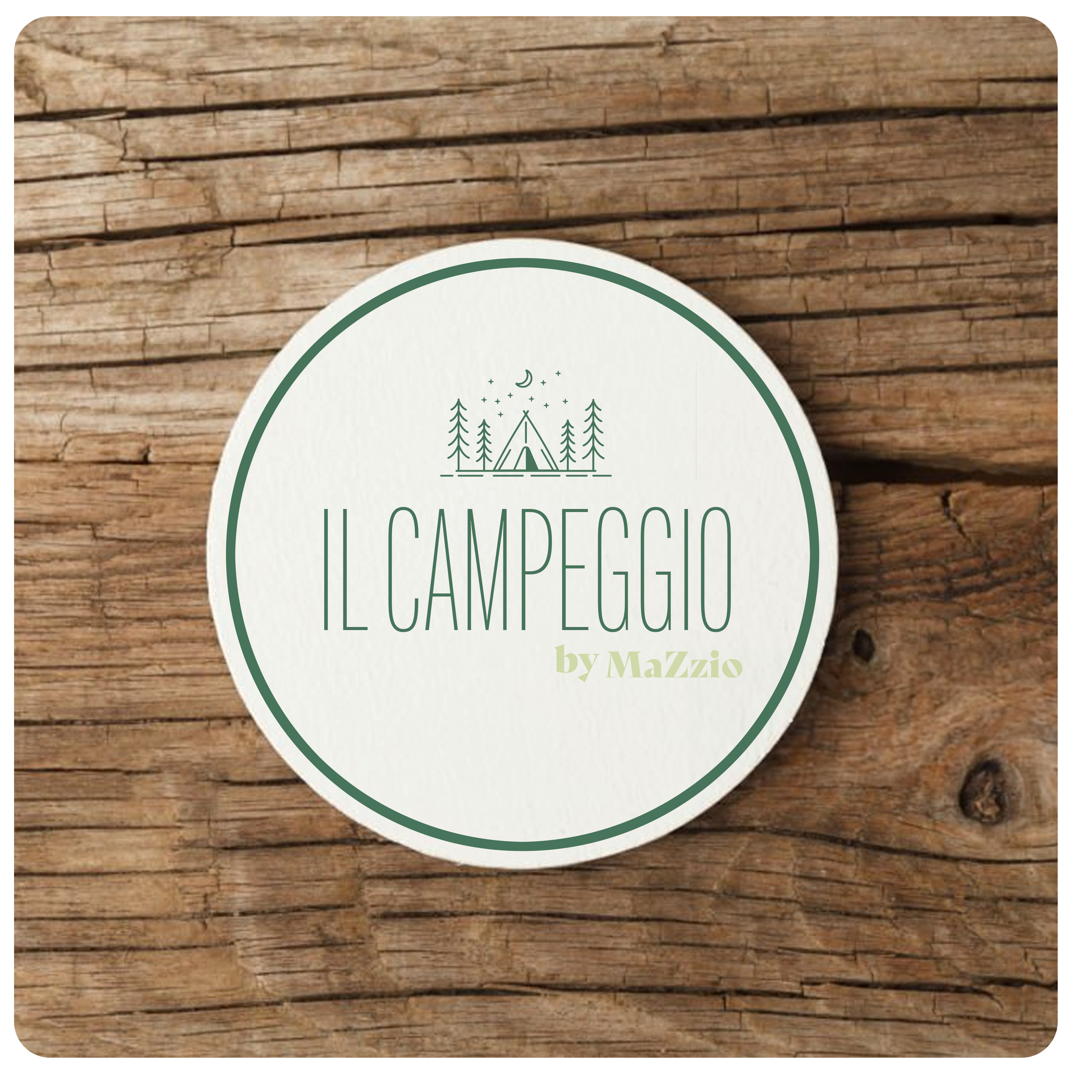 Visuel d'un sous-bock blanc faisant la promotion du camping fictif de MaZzio sur une table en bois de couleur foncé.